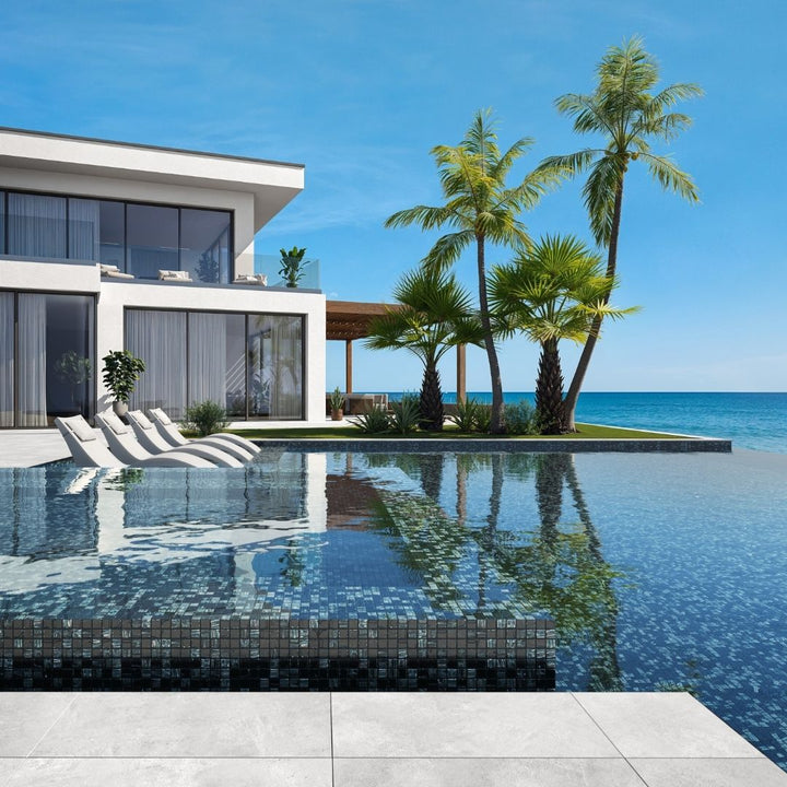 black mosaic glass tile in swimming pool with chairs and palm trees