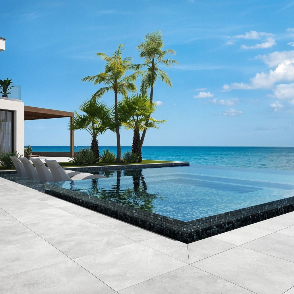 black mosaic glass tile in swimming pool with chairs and palm trees