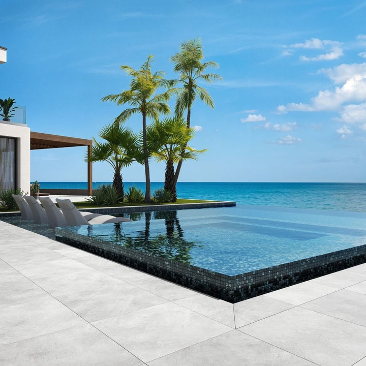 black mosaic glass tile in swimming pool with chairs and palm trees