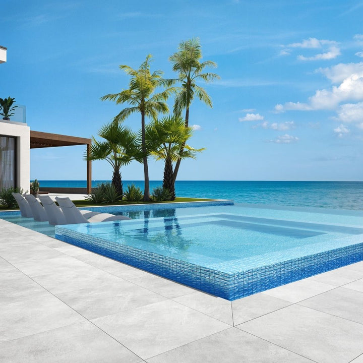 blue mosaic glass tile in swimming pool with chairs and palm trees
