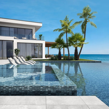 blue mosaic glass tile in swimming pool with chairs and palm trees