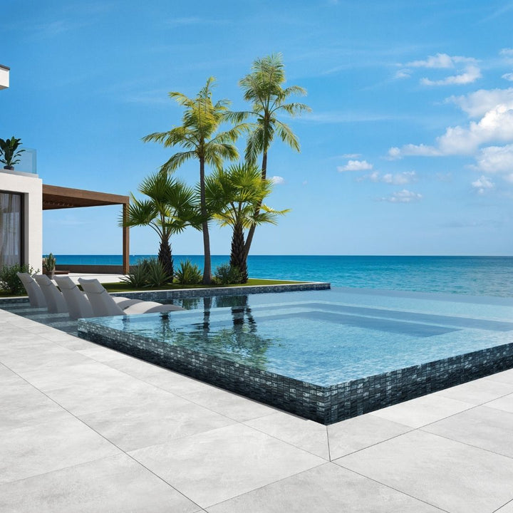 blue mosaic glass tile in swimming pool with chairs and palm trees