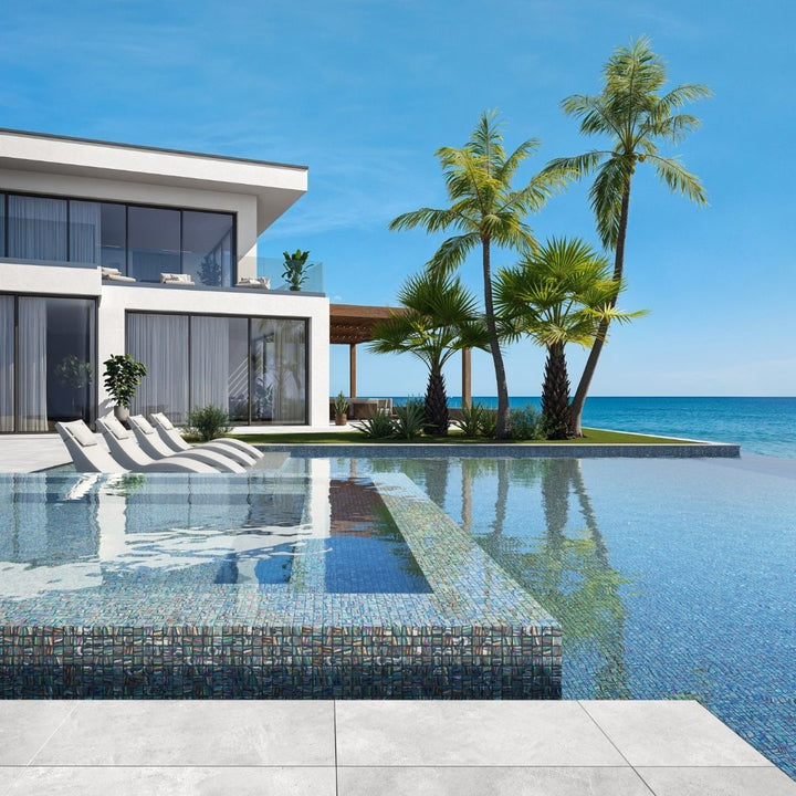 grey mosaic glass tile in swimming pool with chairs and palm trees