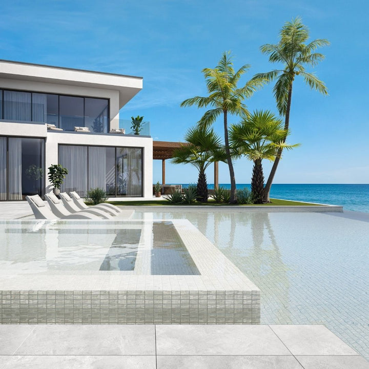 white mosaic glass tile in swimming pool with chairs and palm trees