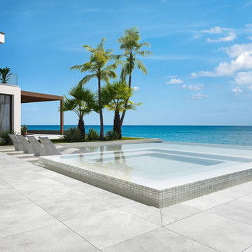 white mosaic glass tile in swimming pool with chairs and palm trees