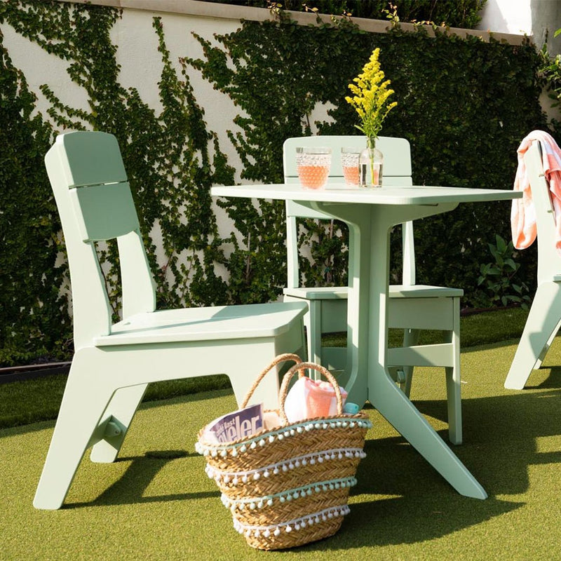 Outdoor furniture set with a table and chairs on a grassy area.